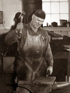 photo of a blacksmith hammering metal on an anvil. The Progress Forge website symbolizes the necessary change we may undergo.